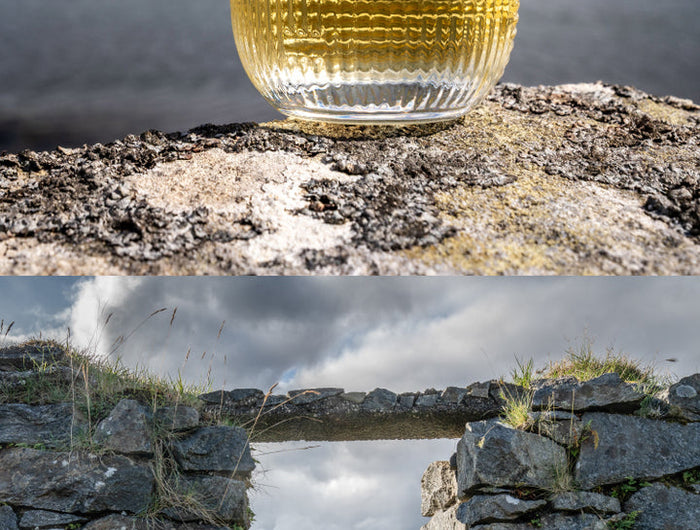 Glass of whisky on a stone surface with a scenic background