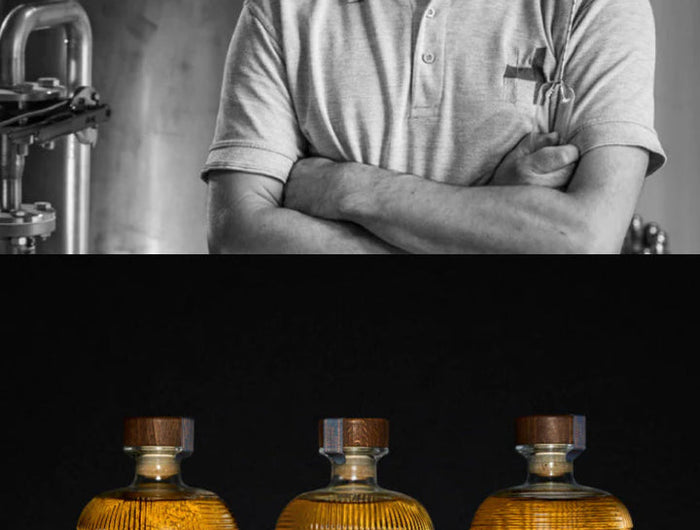 Person standing in front of a distillery with three bottles of Hearach whiskey on a dark background.