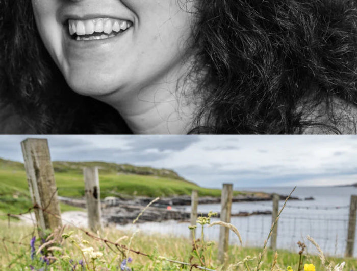 Black and white portrait of a woman with a scenic coastal view below.